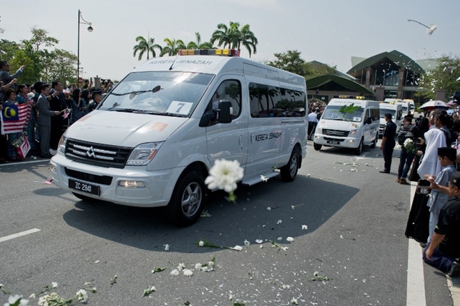 Người dân Malaysia rải hoa trắng ra đường khi đoàn xe chở thi thể nạn nhân MH17 rời khu phức hợp Bunga Raya